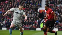 Aksi Anthony Martial melewati bek West Ham, Declan Rice pada laga lanjutan Premier League yang berlangsung di Stadion Old Trafford, Minggu (14/4). Man United menang 2-1 atas West Ham. (AFP/Paul Ellis)
