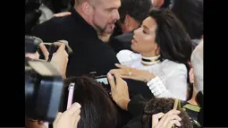 Ketika Kim Kardashian baru saja keluar dari mobilnya, ia tiba-tiba diterjang seorang penggemar yang diketahui bernama Vitalii Sediuk, Paris, (25/9/14). (Dailymail)