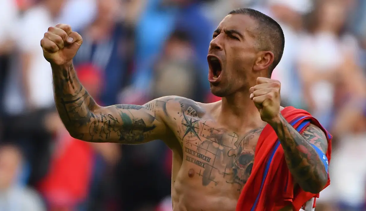 Bek Serbia, Aleksandar Kolarov dengan badan penuh tato merayakan kemenangan timnya di pertandingan sepak bola Grup E Piala Dunia 2018 Rusia di Samara, (17/6). Aleksandar memilih tato ikan koi di bagian lengannya. (AFP PHOTO / Emmanuel Dunand)