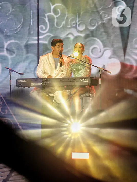 Dalam konser tersebut, Yura Yunita juga tampil berduet dengan suaminya, Donne Maula. Keduanya duduk berdampingan memainkan keyboard sambil menyanyikan lagu “Bercinta Lewat Kata”. (Liputan6.com/Angga Yuniar)