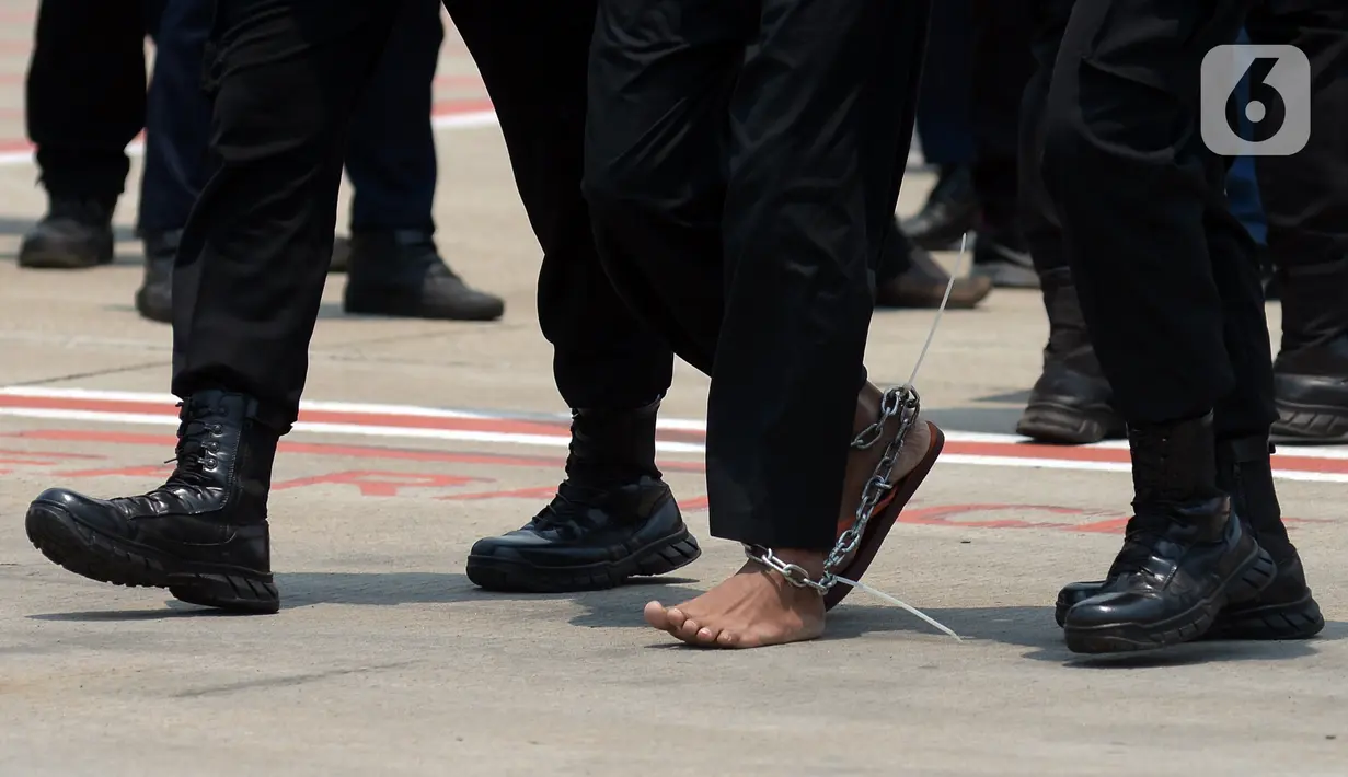 Kaki terduga teroris diborgol saat digiring anggota Densus 88 Antiteror setibanya di Bandara Soekarno-Hatta, Tangerang, Banten, Kamis (18/3/2021). Polri memindahkan 22 terduga teroris jaringan kelompok Jamaah Islamiyah (JI) dari Jawa Timur ke Jakarta. (merdeka.com/Imam Buhori)