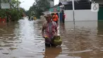 Warga berjalan melewati banjir di Perumahan Ciledug Indah 1 dan 2, Kota Tangerang, Banten, Sabtu (16/7/2022). Banjir tersebut merendam ratusan rumah di dua titik-titik tersebut dengan ketinggian yang bervariasi, mulai dari 50 sentimeter, hingga 1,5 meter. (Liputan6.com/Angga Yuniar)
