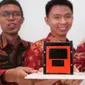 Ilmuwan muda Tim Surya Satellite-1 Muhammad Zulfa Dhiyaulhaq (kiri), Setra Yoman Prahyang (tengah), dan Suhandinata (kanan) menunjukkan satelit nano atau cubesat buatannya sebelum peluncurannya, di Jakarta, Selasa (21/6/12022). (Liputan6.com/Angga yuniar)