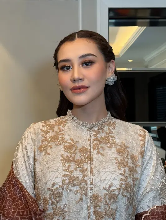 Aaliyah memancarkan pesona anggun saat melangkah di catwalk, mengenakan dress longgar bernuansa beige. Gaun tersebut dihiasi detail bordir coklat yang memperkaya tampilan elegannya.  [@thariqhalilintar/@ochiipramita].