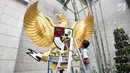 Seorang pria memasang patung Garuda Pancasila di halaman luar Gereja Katedral, Jakarta, Sabtu (23/12). Berbagai dekorasi seperti pohon natal, aksesoris serta tidak ketinggalan patung Garuda Pancasila ditata sedemikian rupa. (Liputan6.com/Angga Yuniar)