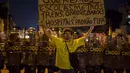 Seorang pengunjuk rasa berdiri di depan polisi anti huru hara selama demonstrasi menentang pengeluaran publik untuk Piala Dunia 2014 di Rio de Janeiro, Brasil, (15/6/2014). (REUTERS/Marco Bello)