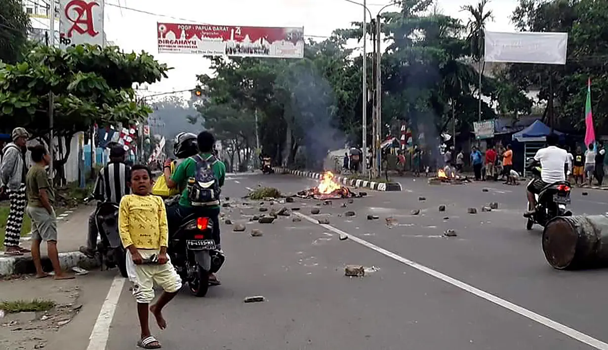 Massa turun ke jalan dalam unjuk rasa yang berujung kerusuhan di Manokwari, Papua, Senin (19/8/2019). Mereka membakar gedung DPR juga memblokade jalan dengan membakar ban sebagai buntut dari peristiwa yang dialami mahasiswa Papua di Surabaya dan Malang, serta Semarang beberapa hari lalu. (STR / AFP)