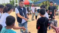 Kader Gerindra di Kabupaten Kampar membagikan susu dan roti kepada anak-anak untuk mendukung program presiden terpilih, Prabowo Subianto. (Liputan6.com/M Syukur)