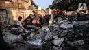 Warga memilah barang yang masih bisa diselamatkan di reruntuhan rumah akibat kebakaran yang melanda pemukiman di jalan Bojong Kavling RT 16/RW04 Kelurahan Rawa Buaya, Jakarta, Rabu (5/1/2022). Kebakaran terjadi Selasa (4/1/2022) menghanguskan setidaknya 14 rumah warga. (Liputan6.com/Johan Tallo)