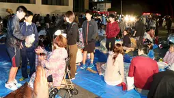 Warga berkumpul di depan sebuah gedung kantor saat gempa bumi 6,4 SR di Mashiki, Prefektur Kumamoto, Jepang selatan, Kamis (14/4). Menurut laporan media Jepang, sekitar 23.000 orang berlindung di sekitar 350 lokasi di Prefektur Kumamoto. (REUTERS/Kyodo)