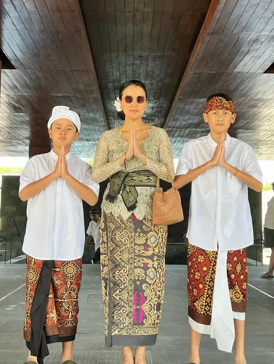 <p>Kedua anak laki-lakinya memilih mengenakan kemeja putih lengan pendek dipadukan kain Bali yang serasi dengan ikat kepalanya. [@marcella.zalianty]</p>