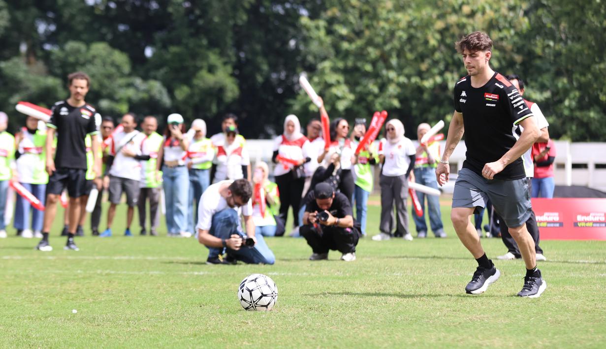 Fabio Di Giannantonio saat menendang bola dalam acara football challenge Pembalap Pertamina Enduro di Stadion Madya, Senayan, Jakarta pada Jumat, (24/1/2025).  (Bola.com/Abdul Aziz)