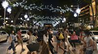 Orang-orang berjalan melewati dekorasi lampu Natal di luar pusat perbelanjaan di sepanjang kawasan Orchard road di Singapura, Selasa (8/12/2020). Mengusung tema Love This Christmas, acara tahun ini lebih sunyi karena aktivitas jalanan dibatasi di tengah pandemi Covid-19. (ROSLAN RAHMAN / AFP)