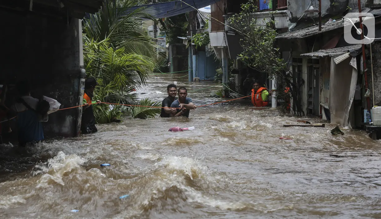Warga berpegangan pada tali saat dievakuasi dari banjir di kawasan Tendean Jakarta, Sabtu (20/2/2021). Curah hujan yang tinggi menyebabkan banjir setinggi orang dewasa di kawasan Tendean. (Liputan6.com/Johan Tallo)
