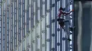 Alain Robert yang dikenal sebagai 'Spiderman Prancis' memanjat gedung pencakar langit Skyper di pusat Frankfurt, Jerman, 23 November 2021. Alain Robert memanjat gedung setinggi 153 meter itu untuk meningkatkan kesadaran dunia tentang masalah perubahan iklim. (AP Photo/Michael Probst)