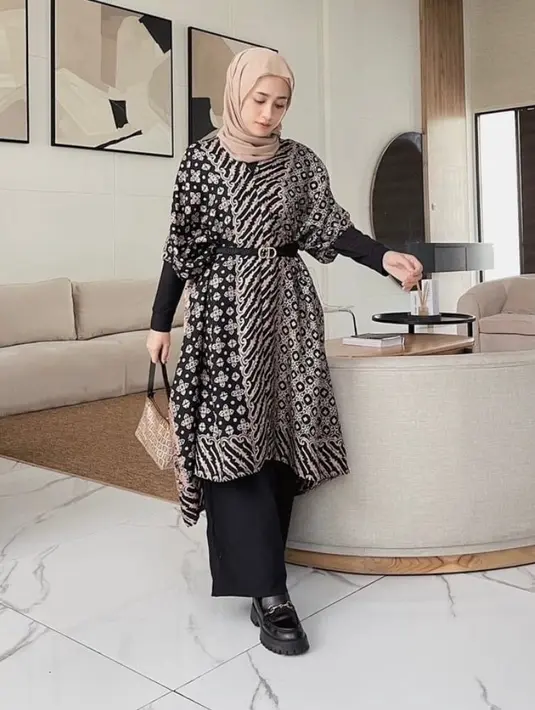 Tunik batik yang loose dan berpotongan asimetris ini dipadu dengan ikat pinggang dan  kulot hitam bakal membuatmu tampil paripurna. (Instagram/ethicmine).