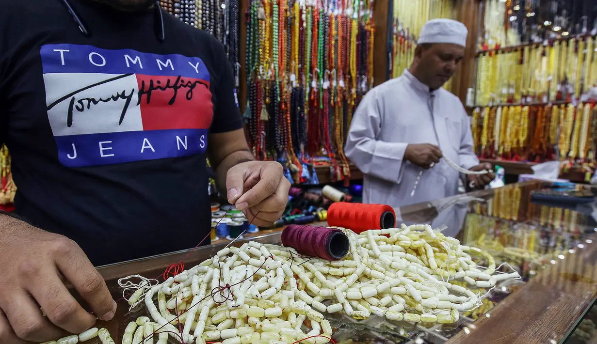 Pedagang saat membuat tasbih untuk dijual selama bulan suci Ramadan di sebuah pasar di Kota Kuwait (25/5/2019). Umat Muslim di seluruh dunia tengah melaksanakan puasa dimana mereka tidak makan, minum mulai dari matahari terbit hingga terbenam. (AFP Photo/Yasser Al-Zayyat)
