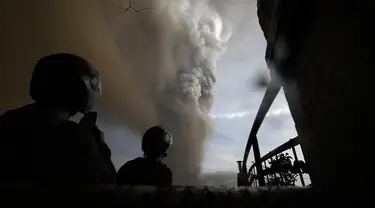 Sejumlah orang menyaksikan Gunung Api Taal erupsi di Tagaytay, Provinsi Cavite, Filipina, Minggu (12/1/2020). Suara bergemuruh terdengar disertai gempa bumi dan kilat di atas puncaknya. (AP Photo/Aaron Favila)