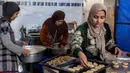 Kaak terbuat dari tepung terigu, minyak zaitun Palestina yang melimpah, dan rempah-rempah aromatik. Tampak dalam foto, para wanita menyiapkan biskuit tradisional "kaak" yang berbentuk cincin menjelang Idul Fitri, hari raya yang menandai berakhirnya bulan puasa suci Ramadan, di Kota Gaza pada 16 Maret 2026. (Omar AL-QATTAA/AFP)
