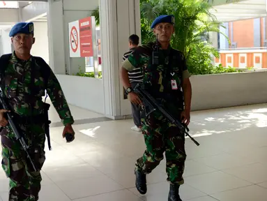 Dua anggota TNI AU melakukan patroli di Bandara Ngurah Rai, Denpasar, Bali, Jumat (15/1). Pasca terjadinya aksi teror di Sarinah, Jakarta, Bandara Ngurah Rai sebagai salah satu pintu masuk menuju Bali meningkatkan keamanan. (AFP PHOTO/Sonny Tumbelaka)