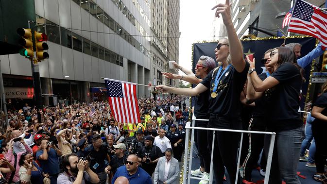 Para pemain timnas sepak bola wanita Amerika Serikat (AS) menaiki kendaraan hias saat parade kemenangan Piala Dunia Wanita 2019 di New York, AS, Rabu (10/7/2019). AS menjuarai Piala Dunia Wanita 2019 usai mengalahkan Belanda di final. (AP Photo/Richard Drew)