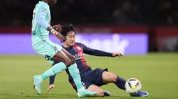 Pemain Paris Saint-Germain, Lee Kang-in, berusaha merebut bola dari pemain Montpellier, Falaye Sacko, pada laga Liga Prancis di Stadion Parc des Princes, Sabtu (4/11/2023). (AFP/Franck Fife)