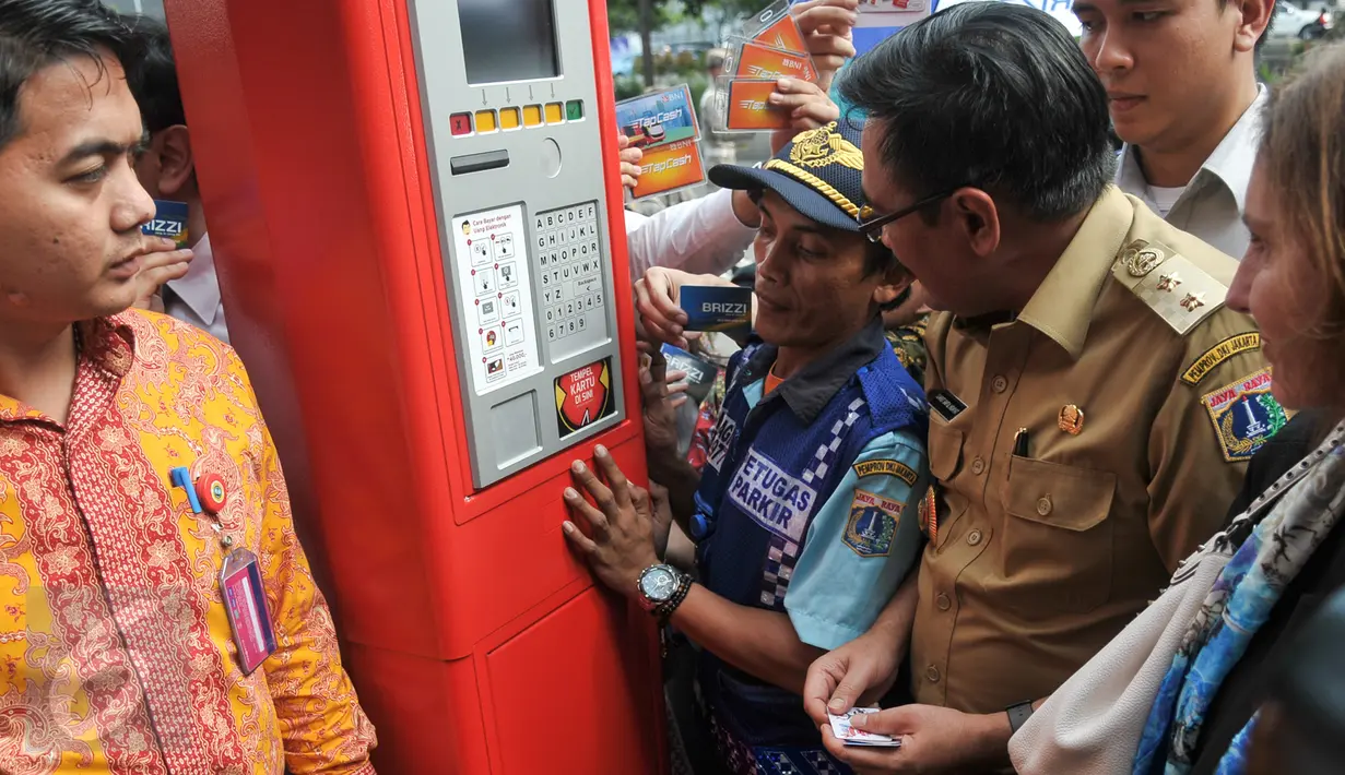 Juru parkir menunjukan cara penggunaan mesin TPE kepada Wagub DKI Jakarta, Djarot Saiful Hidayat, Jakarta, Senin (24/10). Pemprov DKI resmi menerapkan sistem pembayaran parkir pinggir jalan (on street) dengan TPE. (Liputan6.com/Yoppy Renato)