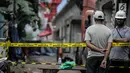 Pekerja berjaga di dekat garis polisi usai ambruknya crane pengerjaan proyek double-double track kereta api di Jatinegara, Jakarta, Minggu (4/2). (Liputan6.com/Faizal Fanani)