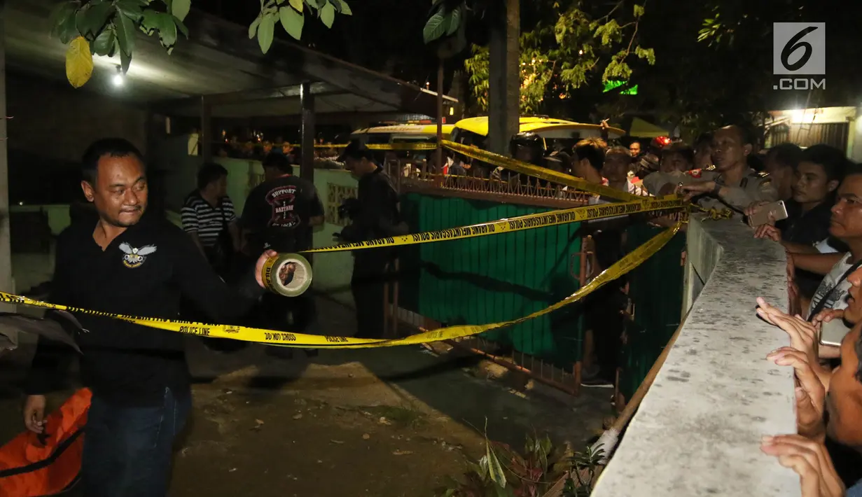 Polisi memasang garis polisi di lokasi  perampokan disertai pembunuhan di komplek TNI AL Pondok Labu, Jakarta, Kamis (5/4). Kejadian yang menewaskan satu orang merupakan purnawirawan TNI AL. (Liputan6.com/Arya Manggala)
