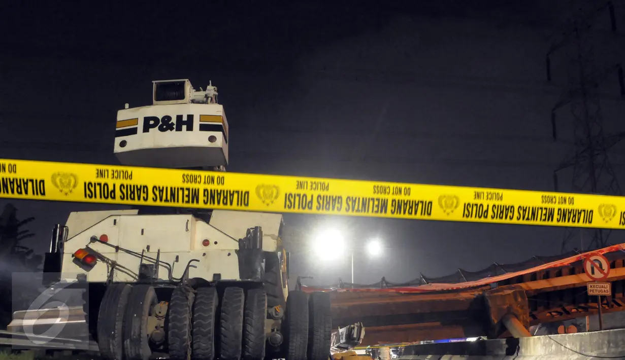 Garis polisi dipasang di dekat robohnya Jembatan Penyeberangan Orang (JPO) di KM 7 Tol BSD, Tangerang Selatan, Minggu (15/5) malam. JPO tersebut roboh setelah ditabrak truk trailer pengangkut crane. (Liputan6.com/Helmi Afandi)