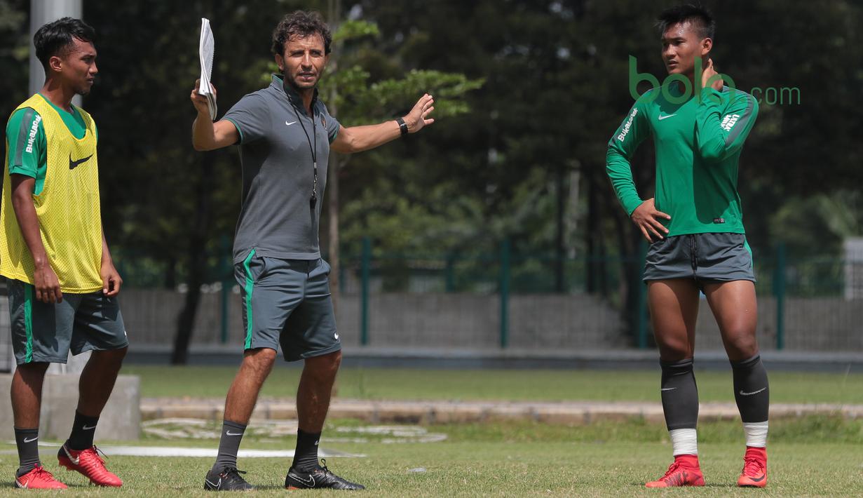 Hargianto (kiri) dan rekannya menyimak arahan pelatih timnas Indonesia, Luis Milla di Lapangan ABC Senayan, Jakarta (21/2/2018). Latihan ini merupakan persiapan Asian Games 2018. (Bola.com/Nick Hanoatubun)