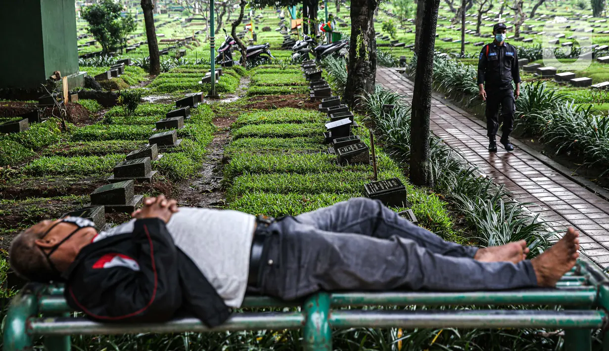 Petugas keamanan berjalan di Tempat Pemakaman Umum (TPU) Karet Bivak, Jakarta, Minggu (27/6/2021). Pemerintah Provinsi DKI Jakarta membatasi aktivitas dan kunjungan ke TPU hingga 5 Juli 2021 untuk menekan penularan COVID-19. (Liputan6.com/Faizal Fanani)