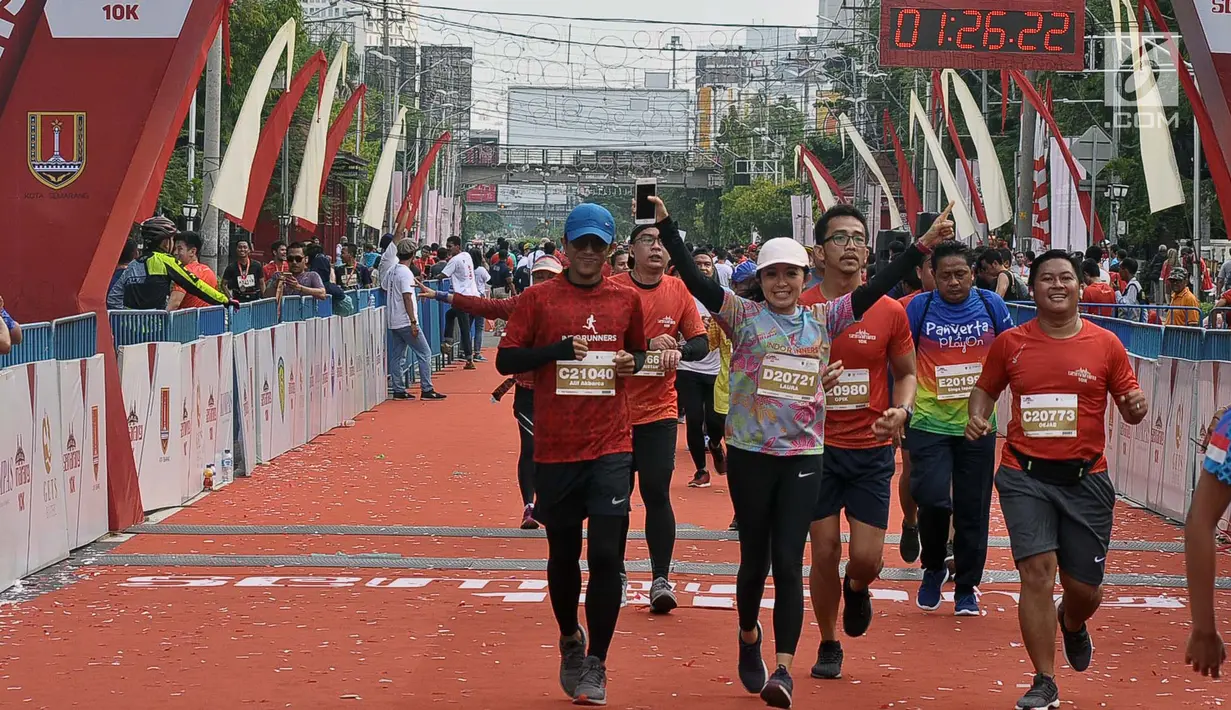 Pelari tiba di garis finish saat mengikuti Semarang 10K di Kota Semarang, Jawa Tengah, Minggu (16/12). Sebanyak 2.000 pelari mengikuti Semarang 10K. (Liputan6.com/Gholib)