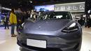 Orang-orang mengamati kendaraan Tesla Model 3 di area ekshibisi otomotif. Pameran Impor Internasional China (China International Import Expo/CIIE) ketiga di Shanghai, China timur (5/11/2020). (Xinhua/Zhao Dingzhe)