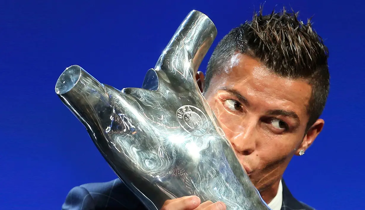 Penyerang Real Madrid, Cristiano Ronaldo mencium trofi setelah terpilih sebagai Pemain Terbaik Eropa musim 2015-2016 usai drawing penyisihan grup Liga Champions di Monako, (25/8). (REUTERS/Eric Gaillard)