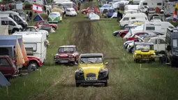 Mobil-mobil melewati kamp selama pertemuan dunia Citroen 2CV Friends di dekat Delemont, Swiss, 26 Juli 2023. (GABRIEL MONNET/AFP)
