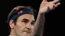 Petenis Swiss, Roger Federer bersiap mengembalikan bola ke arah Taylor Fritz dari AS dalam babak 32 besar Australia Terbuka di Melbourne, Jumat (18/1). Federer melaju mulus ke babak 16 besar setelah menang tiga set langsung 6-2 7-5 6-2. (AP/Kin Cheung)