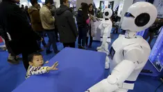 Seorang saat melihat Robot yang berbentuk mirip manusia yang bernama Robot KINGER pada Pameran Dunia Robot selama Konferensi Robot Dunia di Beijing, Cina,  (24/11). Konferensi robot ini diadakan selama tiga hari dari senin lalu. (REUTERS/Jason Lee)
