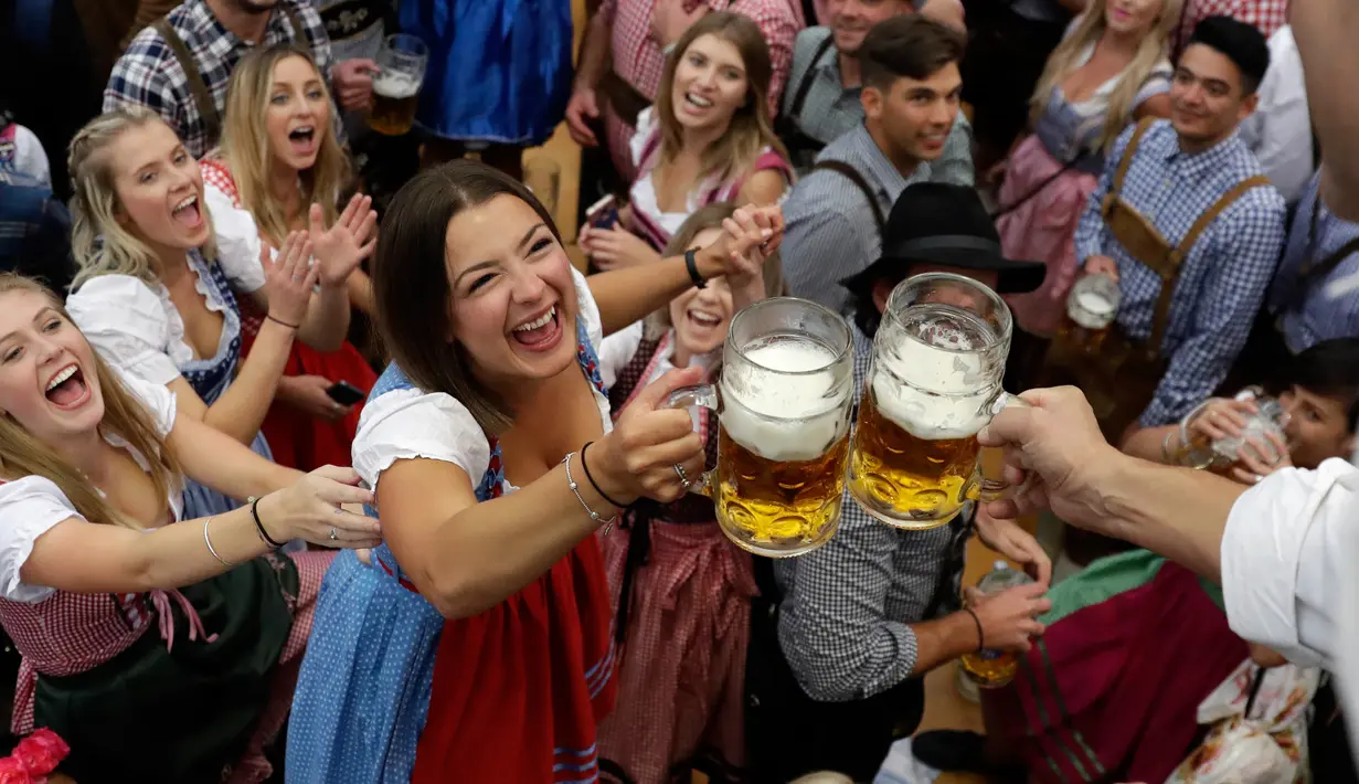 Seorang wanita mengambil gelas bir selama pembukaan festival bir Oktoberfest di 184, Munich, Jerman, (16/9). Festival ini diadakan dari tanggal 16 sampai 3 Oktober 2017. (AP Photo / Matthias Schrader)