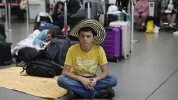Penumpang Viva Air duduk di area check-in setelah maskapai berbiaya rendah itu menangguhkan operasinya di Bandara Internasional El Dorado di Bogota, Kolombia, Selasa (28/2/2023). Penumpang di Kolombia dengan tiket Viva Air untuk 27 atau 28 Februari atau 1 Maret ke Lima atau Mexico City, akan ditawarkan penerbangan dengan Latam atau Avianca tanpa biaya tambahan, tergantung ketersediaan kursi, kata otoritas tersebut. (AP Photo/Fernando Vergara)