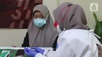 Vaksinator memberikan penjelasan kepada tenaga kesehatan yang akan di vaksin dosis ketiga atau booster di RSUD Matraman, Jakarta, Jumat (6/8/2021). Pemberian vaksin dosis ketiga kepada tenaga kesehatan di Indonesia ditargetkan rampung pada pekan kedua Agustus 2021 (Liputan6.com/Herman Zakharia)
