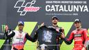 Miguel Oliviera memegang kaos bergambar pebalap Moto3 yang tewas, Jason Dupasquier bersama Johan Zarco dan Jack Miller yang finish di posisi kedua dan ketiga. (Foto: AFP/Lluis Gene)