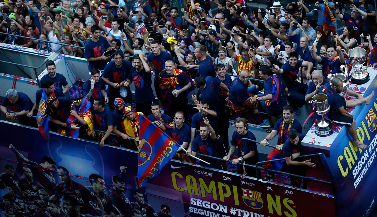 Para pemain Barcelona menyapa para pengemarnya dari atas bus saat melakukan parade di Barcelona, Spanyol (7/6/2015). Barcelona sukses meraih 'treble winners' usai mengalahkan Juventus di final Liga Champions. (REUTERS/Albert Gea)