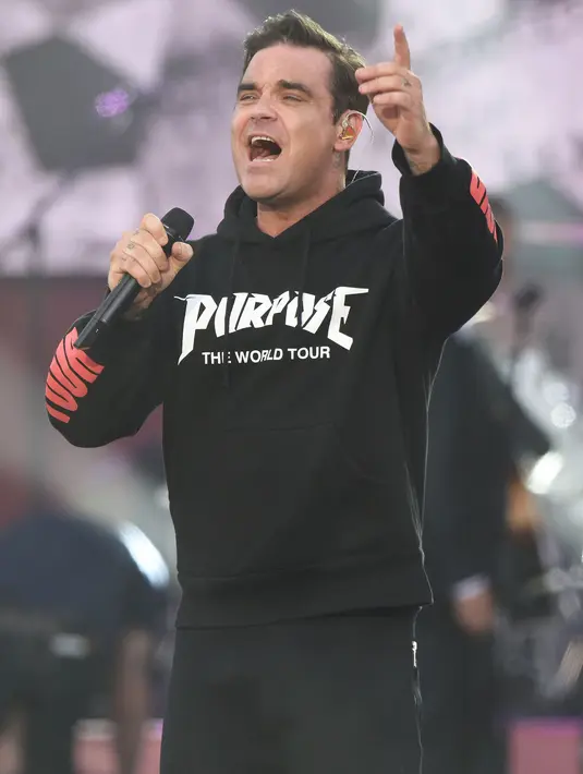 <p>Penyanyi Robbie Williams tampil membawakan lagu dalam konser amal bertajuk "One Love Manchester" di Manchester, Minggu (4/6). Konser itu untuk mengenang dan menggalang dana bagi para korban bom di konser Ariana Grande 22 Mei silam. (Dave Hogan via AFP)</p>