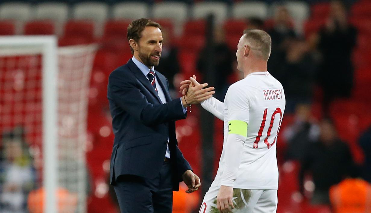 Usai pertandingan, Wayne Rooney bersalaman dengan sang pelatih Gareth Southgate pada laga persabahatan kontra Amerika Serikat yang berlangsung di Stadion Wembley, Inggris. Timnas Inggris menang 3-0. (AFP/Ian Kington)