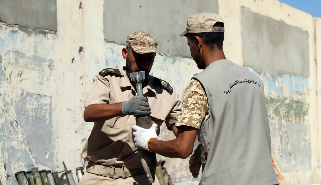 Pasukan pemerintah Libya yang didukung PBB memindahkan sisa-sisa bahan peledak di sebuah kamp militer di Tripoli selatan, Libya (22/7/2020). (Xinhua/Hamza Turkia)