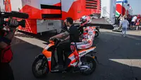 Momen Marc Marquez dibonceng kru tim Repsol Honda usai kecelakaan pada warm rup MotoGP Jerman 2023 di Sirkuit Sachsenring hari Minggu (18/06/2023). (Ronny Hartmann / AFP)