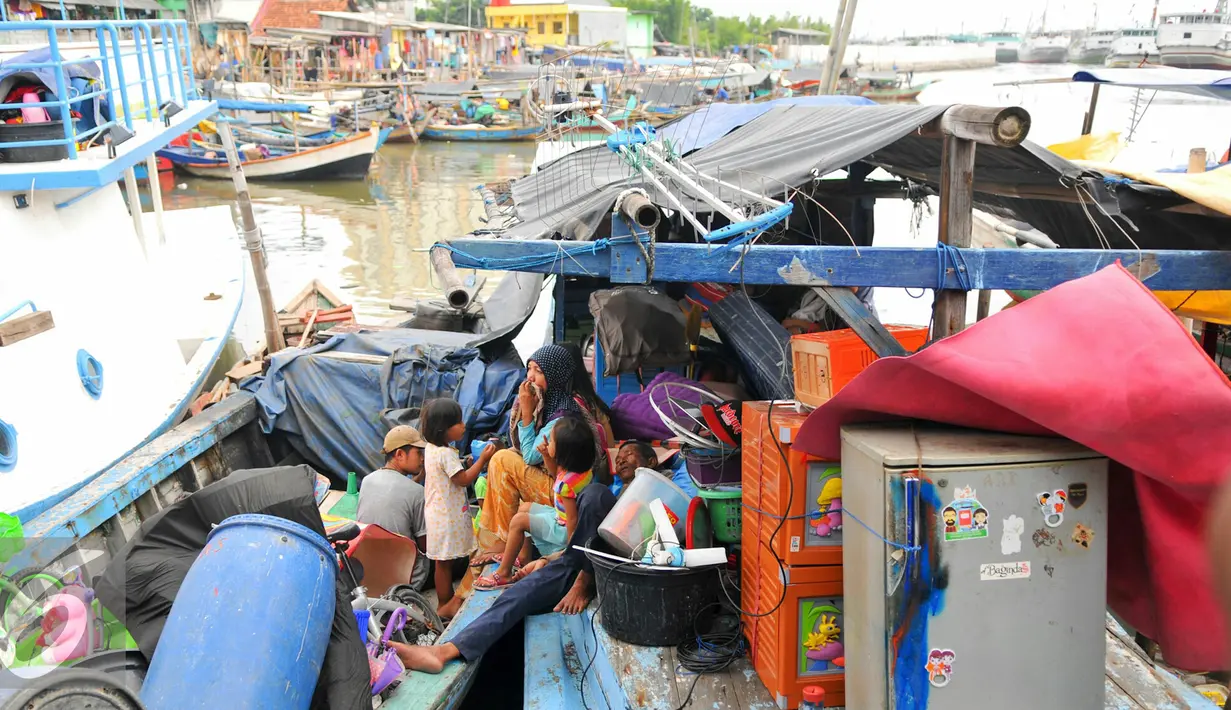 Sejumlah penghuni Pasar Ikan, Penjaringan mengungsi ke perahu nelayan untuk menyelamatkan barang-barang saat pembongkaran, Jakarta, Senin (11/4). Pemprov DKI membongkar ratusan rumah di wilayah Pasar Ikan. (Liputan6.com/Yoppy Renato)