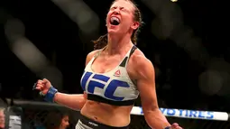 Atlet tarung bebas, Miesha Tate, merayakan kemenangan atas Holly Holm dalam UFC 196 di MGM Grand Garden Arena, Las Vegas, AS. (5/3/2016). (Reuters/USA TODAY Sports/Mark J. Rebilas)