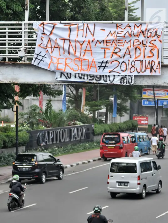 Spanduk dukungan Persija yang terpasang di JPO, Jakarta, Minggu (9/12). Jelang laga penentuan pekan ke-34 Liga 1 antara Persija melawan Mitra Kukar, spanduk dukungan juara The Jakmania bermunculan di JPO jalan Ibu Kota. (Merdeka.com/Iqbal S. Nugroho)
